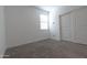 Bedroom featuring neutral carpet, white walls, window, and a sliding-door closet at 19975 W Glenrosa Ave, Litchfield Park, AZ 85340