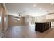 Open-concept kitchen and living area with a dark island, stainless steel appliances, and wood-look tile flooring at 19975 W Glenrosa Ave, Litchfield Park, AZ 85340