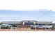 Street view of Village Grove shopping center, adorned with colorful flags and lined with parked cars at 19975 W Glenrosa Ave, Litchfield Park, AZ 85340