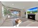 Modern living room with a cozy fireplace, TV, comfortable sofa, and view of the backyard pool at 19990 W Turney Ave, Litchfield Park, AZ 85340