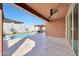 Covered patio featuring ceiling fan, tile flooring, and views of the pristine backyard pool and cabana area at 19990 W Turney Ave, Litchfield Park, AZ 85340