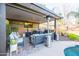 An entertaining outdoor covered patio featuring an outdoor kitchen, seating and a ceiling fan at 20138 E Estrella Rd, Queen Creek, AZ 85142