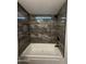 Bathroom bathtub with stylish gray marble tile surround and dark modern fixtures at 2034 E Charleston Ave, Phoenix, AZ 85022