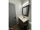 Bathroom vanity with a wooden frame mirror, modern light fixture, and new sink at 2034 E Charleston Ave, Phoenix, AZ 85022