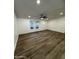 Spacious living room featuring wood-look flooring, a modern ceiling fan, and bright natural light at 2034 E Charleston Ave, Phoenix, AZ 85022