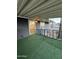 Covered patio features artificial turf, black railings, and view to the home's interior at 2034 E Charleston Ave, Phoenix, AZ 85022