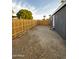 A side yard with new wooden fence and gravel, with steps leading into the home at 2034 E Charleston Ave, Phoenix, AZ 85022