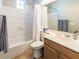 Clean bathroom with white shower curtain, modern toilet and wooden vanity at 21134 W Green St, Buckeye, AZ 85396