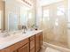 Bright bathroom with double sinks, wooden cabinets and glass shower doors at 21134 W Green St, Buckeye, AZ 85396