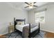 Cozy bedroom with black bed frame, ceiling fan, and window with shutter, plus wood floors and area rug at 2170 E Caroline Ln, Tempe, AZ 85284