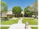 Charming single-story home with a lush green lawn, mature trees, and a curved walkway leading to the front door at 2170 E Caroline Ln, Tempe, AZ 85284