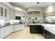 Spacious kitchen with black countertops, white cabinets, a dining area, and ample lighting at 2170 E Caroline Ln, Tempe, AZ 85284