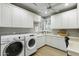 Well-organized laundry room featuring ample cabinet space, a sink, and a front-load washer/dryer at 2170 E Caroline Ln, Tempe, AZ 85284