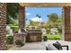 Built-in grill area on covered patio overlooks the pool and landscaped backyard at 2170 E Caroline Ln, Tempe, AZ 85284