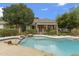 Backyard pool area has mature landscaping, large rocks, and wrought iron fence surrounding pool at 2170 E Caroline Ln, Tempe, AZ 85284