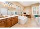 Bright bathroom with separate vanities, a soaking tub, and a glass block window at 22813 N Del Monte Dr, Sun City West, AZ 85375