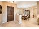 Inviting foyer featuring a solid wood front door, tile flooring, and an elegant dining area at 22813 N Del Monte Dr, Sun City West, AZ 85375