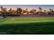 Scenic view of the well-manicured golf course at sunset, with vibrant green fairways and palm trees lining the landscape at 22813 N Del Monte Dr, Sun City West, AZ 85375