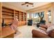 Inviting living room with a ceiling fan, plush seating, and a golf course view from the bay window at 22813 N Del Monte Dr, Sun City West, AZ 85375