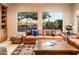 Bright living room with large windows, leather furniture, and a decorative rug at 22813 N Del Monte Dr, Sun City West, AZ 85375