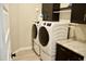 Laundry room features two front-loading washer and dryers and dark wood cabinets at 22891 E Via Del Sol --, Queen Creek, AZ 85142