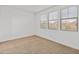 This naturally lit bedroom features three windows, carpeted floors and neutral walls at 2460 E Athena Ave, Gilbert, AZ 85297