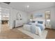 This staged bedroom features neutral colors, a decorative mirror, and doorway to the billiard room at 2460 E Athena Ave, Gilbert, AZ 85297