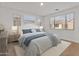 This staged bedroom features neutral colors, a large window, and a white area rug at 2460 E Athena Ave, Gilbert, AZ 85297