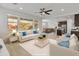 Bright staged living room open to the kitchen, featuring neutral decor and large windows for natural light at 2460 E Athena Ave, Gilbert, AZ 85297