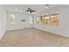 Bright empty living room with tiled floors, ceiling fan, and large windows offering natural light at 2460 E Athena Ave, Gilbert, AZ 85297