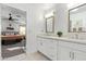 Bright and airy bathroom featuring double sinks with white cabinets and a view to the bedroom at 2638 E Edgemont Ave, Phoenix, AZ 85008