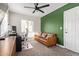 Home office with a green accent wall, modern desk, and neutral-toned sofa at 2638 E Edgemont Ave, Phoenix, AZ 85008