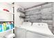 This laundry room features modern washer and dryer, wood plank accent wall, and white shelving at 2824 N 42Nd Way, Phoenix, AZ 85008