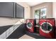 Laundry room featuring front load washer and dryer on raised platforms, with cabinets and a window at 2977 E Teakwood Pl, Chandler, AZ 85249