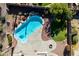 Aerial view of a backyard featuring a kidney-shaped pool, a grassy area, desert landscaping and a fire pit at 2977 E Teakwood Pl, Chandler, AZ 85249