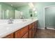 A large bathroom with dual sinks, wood cabinets, and a tile floor provides a comfortable space for relaxation at 30153 N Gecko Trl, San Tan Valley, AZ 85143