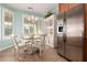 Charming breakfast nook with tile floors, white wood table set, and stainless steel refrigerator at 30153 N Gecko Trl, San Tan Valley, AZ 85143