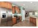 An open kitchen features stainless steel appliances and wood cabinetry with tile flooring and natural lighting at 30153 N Gecko Trl, San Tan Valley, AZ 85143