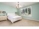 A serene main bedroom featuring a chandelier, neutral colors, and large window with plantation shutters at 30153 N Gecko Trl, San Tan Valley, AZ 85143