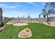 Lush backyard with artificial turf, desert landscaping, and stone benches in a tranquil desert setting at 30600 N Pima Rd # 24, Scottsdale, AZ 85266