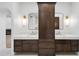 Elegant bathroom featuring dual vanities, a central storage cabinet, and modern lighting fixtures at 30600 N Pima Rd # 24, Scottsdale, AZ 85266