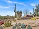 Community entrance with lush desert landscaping, rock features, and mountain views at 30600 N Pima Rd # 24, Scottsdale, AZ 85266