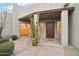 Inviting home entrance with a desert landscape, a covered entryway, and a solid wood front door at 30600 N Pima Rd # 24, Scottsdale, AZ 85266