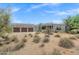 Gorgeous Southwestern house with a three-car garage, showcasing the natural desert landscaping in the front yard at 30600 N Pima Rd # 24, Scottsdale, AZ 85266