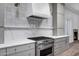 Modern kitchen showcases stainless steel oven, white stone countertop, and custom range hood and tiling at 30600 N Pima Rd # 24, Scottsdale, AZ 85266
