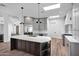 Open concept kitchen with gray cabinetry, a large island and modern appliances and wood floors at 30600 N Pima Rd # 24, Scottsdale, AZ 85266