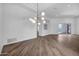 Open living room featuring stylish hardwood floors, modern chandelier, and seamless flow to outdoor patio with pool at 30600 N Pima Rd # 24, Scottsdale, AZ 85266