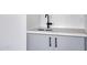Close-up of wet bar with stainless steel sink, gray cabinets and sleek black faucet at 30600 N Pima Rd # 24, Scottsdale, AZ 85266