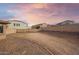 Large backyard with gravel, stone, block wall fence, and sunset sky at 34705 N 26Th Ave, Phoenix, AZ 85086