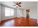 Empty living room with hardwood floors, ceiling fan, and a large window at 34705 N 26Th Ave, Phoenix, AZ 85086